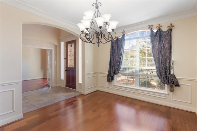 interior space with an inviting chandelier, crown molding, and hardwood / wood-style flooring