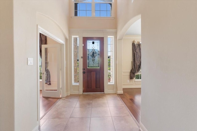 tiled foyer featuring crown molding