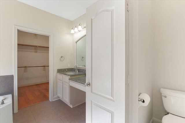 bathroom featuring vanity, tile patterned floors, and toilet