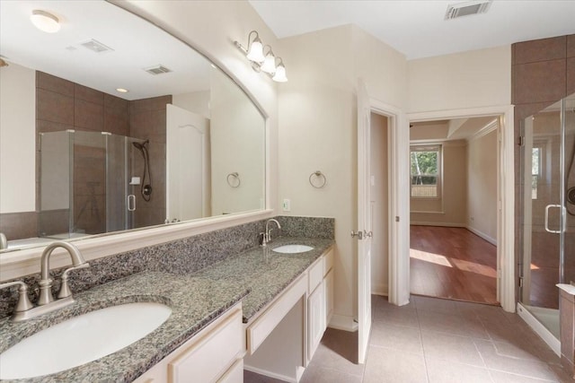 bathroom featuring vanity, a shower with door, and tile patterned flooring