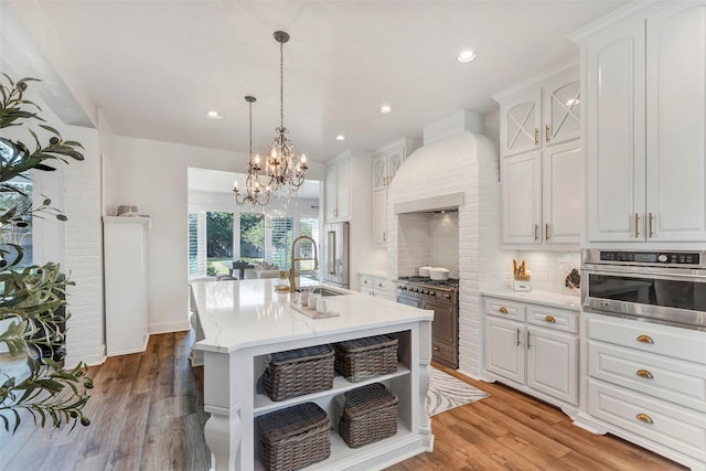 kitchen featuring sink, white cabinetry, stainless steel appliances, tasteful backsplash, and custom range hood