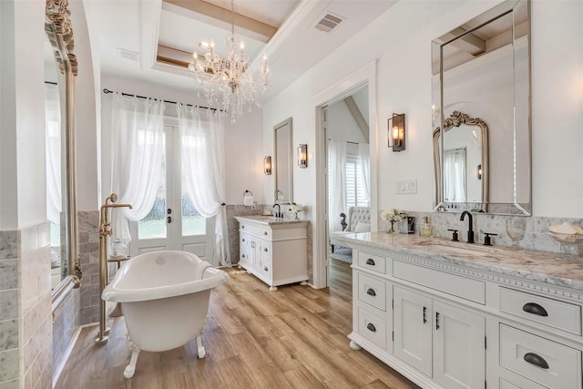 bathroom featuring hardwood / wood-style floors, french doors, a healthy amount of sunlight, and a bath