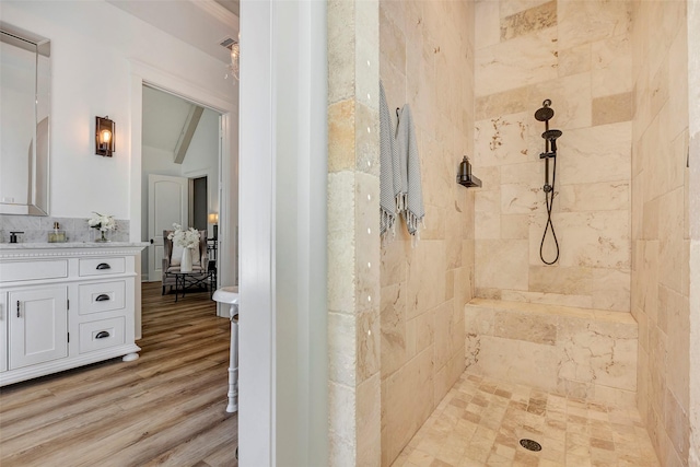 bathroom featuring lofted ceiling with beams, vanity, tiled shower, and hardwood / wood-style floors