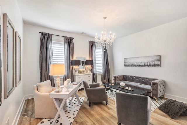 living room with an inviting chandelier and light hardwood / wood-style flooring