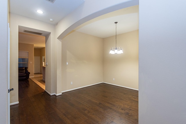 unfurnished room with dark hardwood / wood-style floors and a notable chandelier