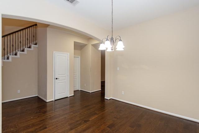 unfurnished room featuring dark hardwood / wood-style floors and an inviting chandelier