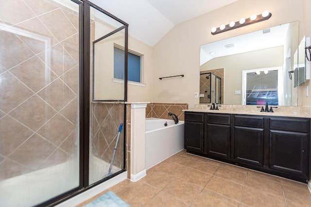 bathroom featuring tile patterned flooring, vaulted ceiling, independent shower and bath, and vanity