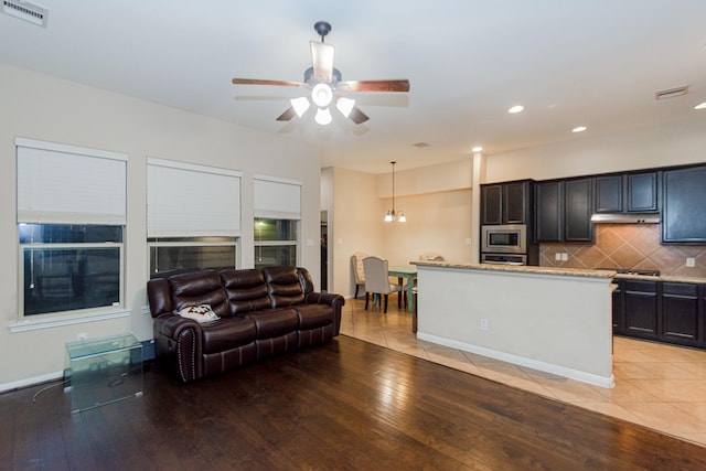 living room with ceiling fan and light hardwood / wood-style flooring