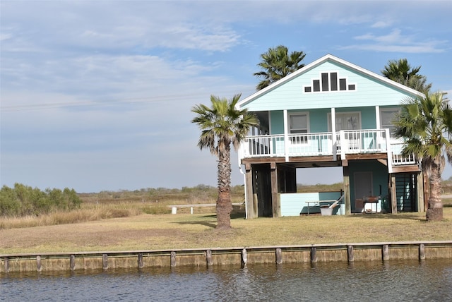 back of house with a yard and a water view