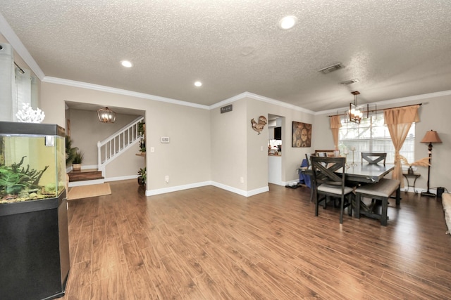 dining area with crown molding, a textured ceiling, and a chandelier