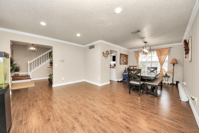 dining room with ornamental molding, a notable chandelier, and a textured ceiling