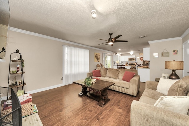 living room featuring ceiling fan, crown molding, dark wood-type flooring, and a textured ceiling