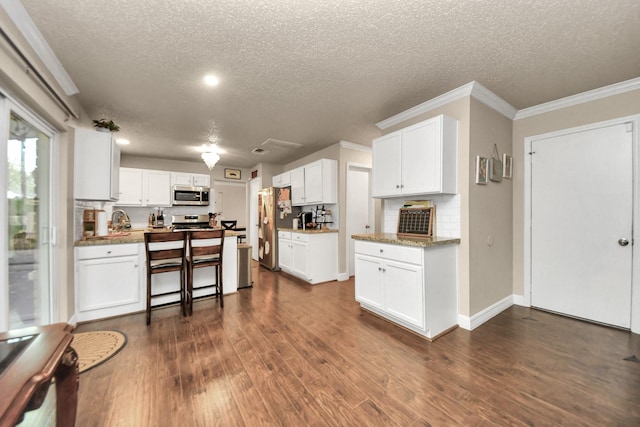 kitchen with white cabinetry, a textured ceiling, and appliances with stainless steel finishes