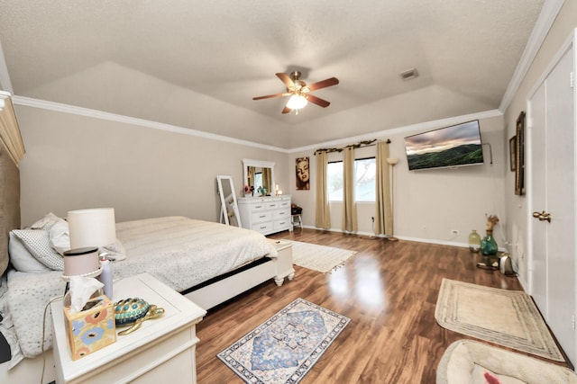 bedroom featuring dark hardwood / wood-style floors, ornamental molding, ceiling fan, a raised ceiling, and a textured ceiling