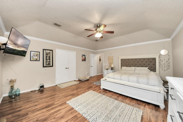 bedroom featuring ornamental molding, a textured ceiling, ceiling fan, and a tray ceiling