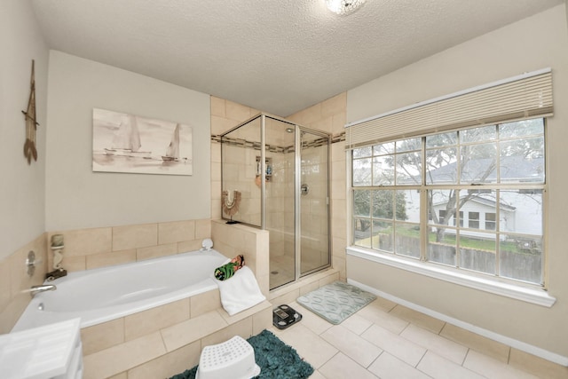 bathroom with tile patterned flooring, a wealth of natural light, shower with separate bathtub, and a textured ceiling