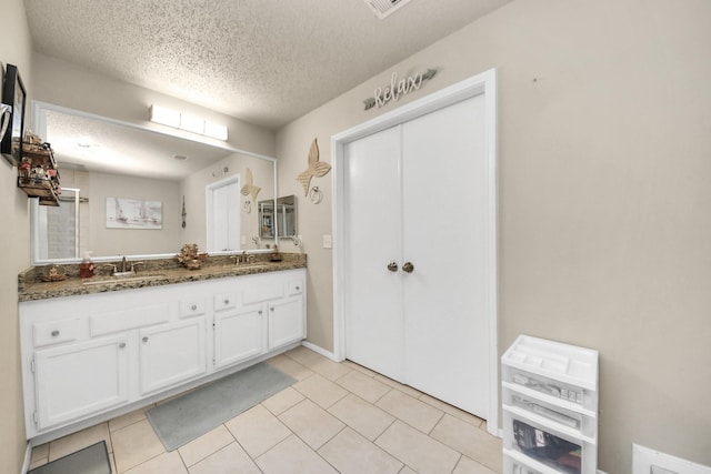 bathroom featuring tile patterned floors, vanity, and a textured ceiling