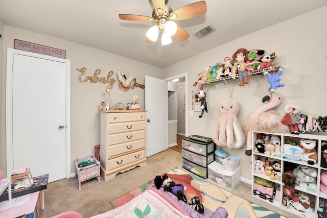 bedroom with light colored carpet, a textured ceiling, and ceiling fan