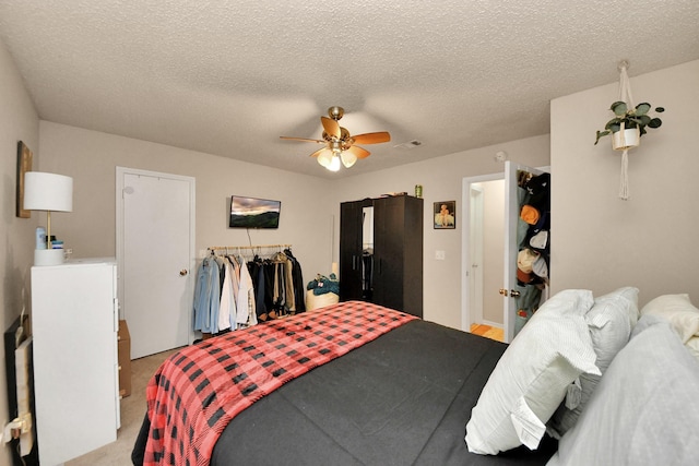 carpeted bedroom with a textured ceiling and ceiling fan