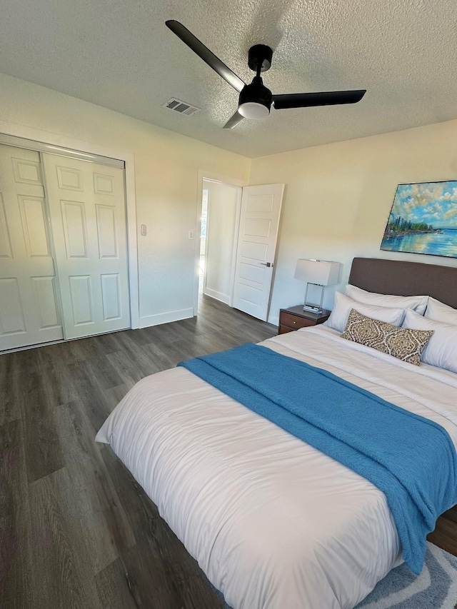 bedroom featuring ceiling fan, dark wood-type flooring, a textured ceiling, and a closet