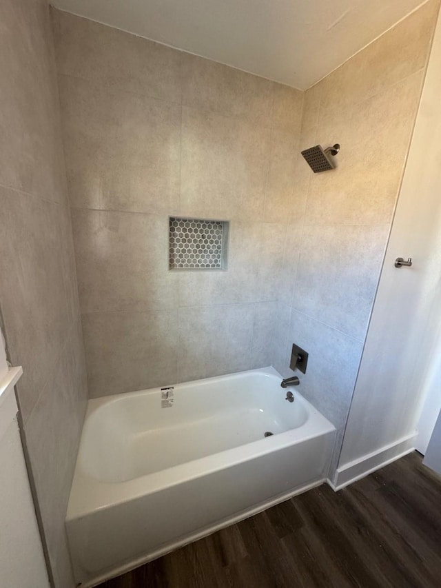 bathroom with hardwood / wood-style flooring and tiled shower / bath combo