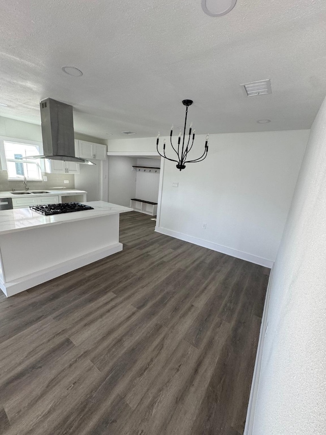 kitchen with sink, stainless steel gas cooktop, decorative light fixtures, dark hardwood / wood-style flooring, and island exhaust hood