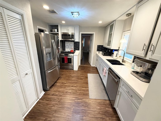 kitchen featuring stainless steel appliances, white cabinetry, tasteful backsplash, and sink