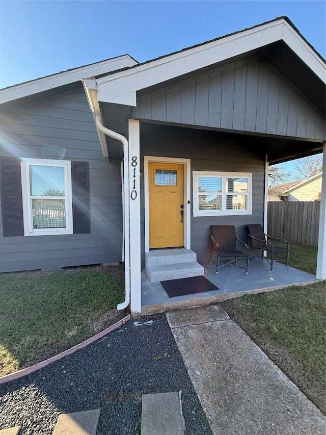 entrance to property with a yard and fence