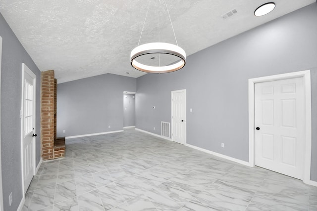 spare room with vaulted ceiling and a textured ceiling