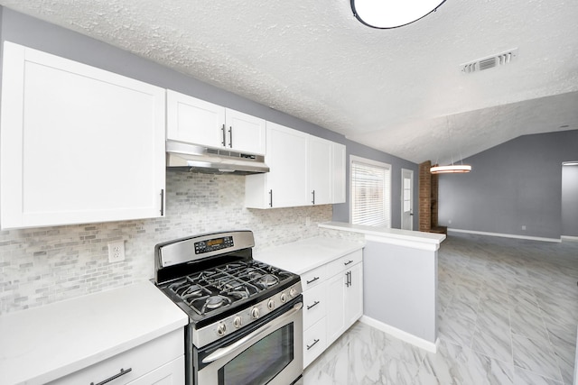 kitchen with tasteful backsplash, lofted ceiling, white cabinets, gas range, and a textured ceiling