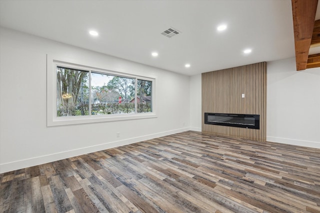 unfurnished living room featuring hardwood / wood-style floors and a large fireplace