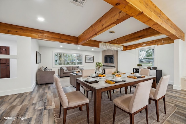 dining space featuring hardwood / wood-style floors, beam ceiling, and plenty of natural light