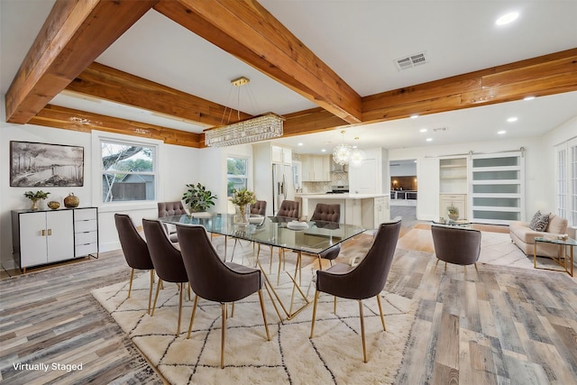 dining space featuring beamed ceiling and light hardwood / wood-style floors