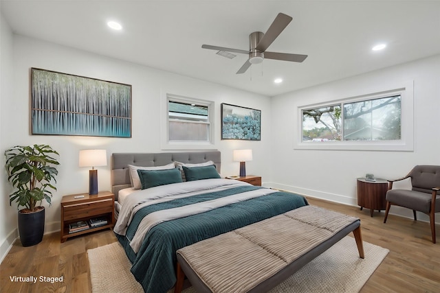 bedroom with multiple windows, hardwood / wood-style floors, and ceiling fan