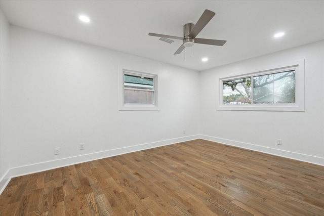 empty room featuring hardwood / wood-style flooring, ceiling fan, and a healthy amount of sunlight