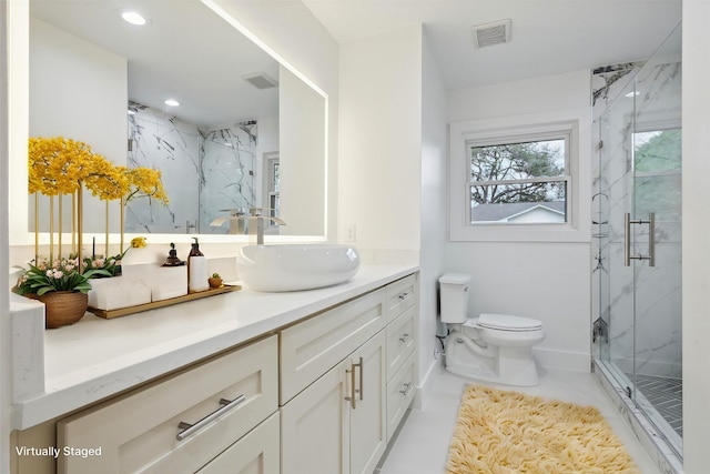 bathroom with vanity, toilet, and a shower with door