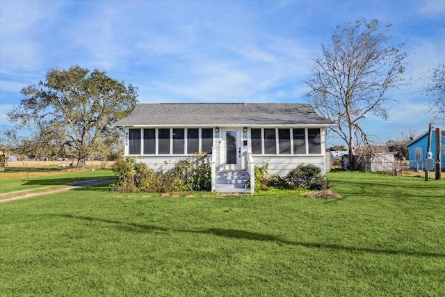 ranch-style home featuring a sunroom and a front yard