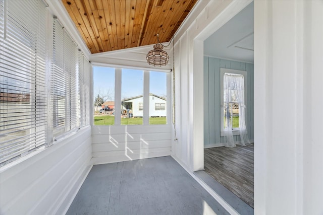 unfurnished sunroom featuring vaulted ceiling and wooden ceiling