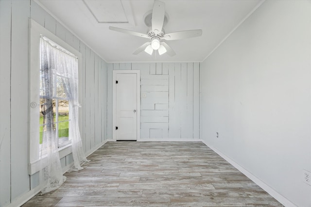 empty room featuring crown molding, light hardwood / wood-style flooring, and ceiling fan