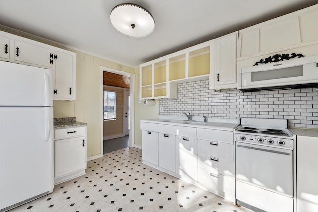 kitchen featuring sink, white appliances, white cabinets, and backsplash