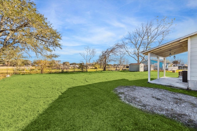 view of yard with a storage shed and a patio