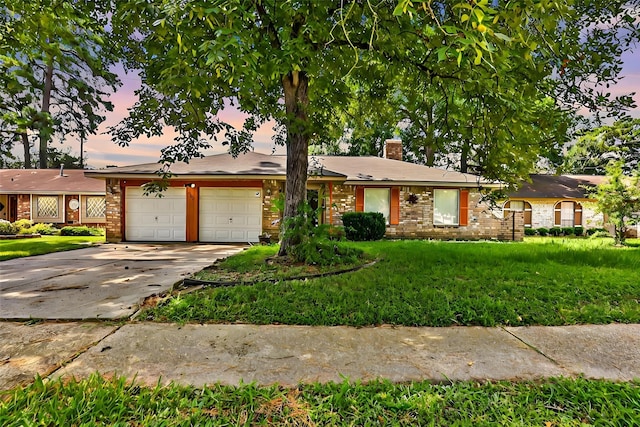 ranch-style home with an attached garage, driveway, a chimney, and a front yard