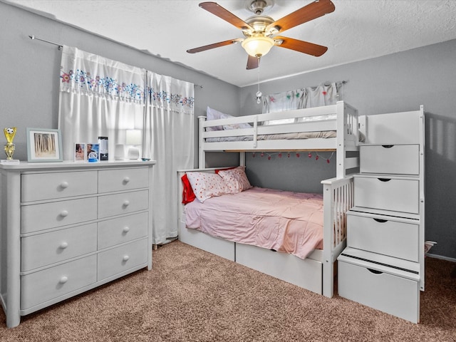 bedroom with a textured ceiling, ceiling fan, and carpet flooring