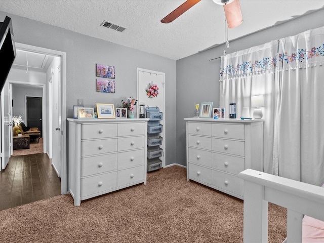 carpeted bedroom featuring ceiling fan and a textured ceiling