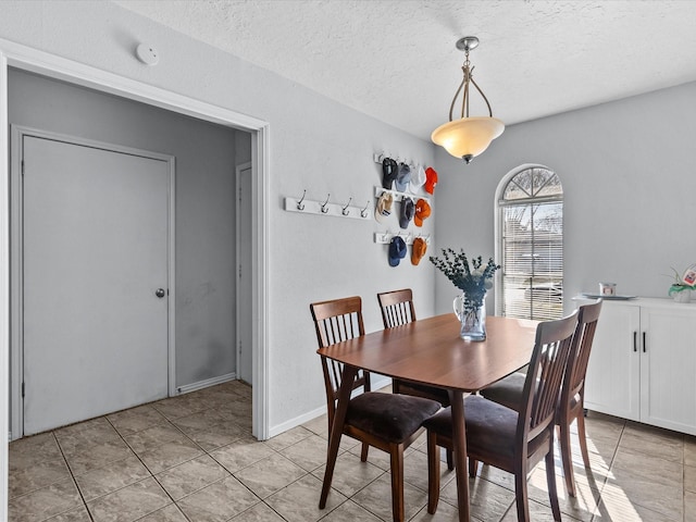 dining space with light tile patterned floors and a textured ceiling