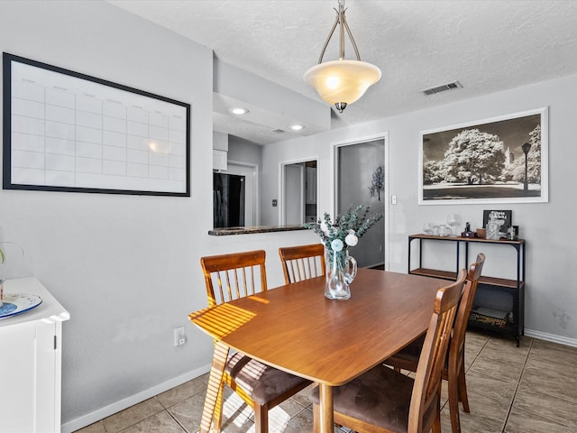 dining room with light tile patterned floors and a textured ceiling