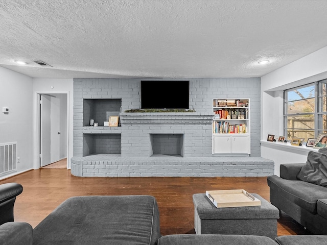 living room featuring hardwood / wood-style floors, a fireplace, and a textured ceiling