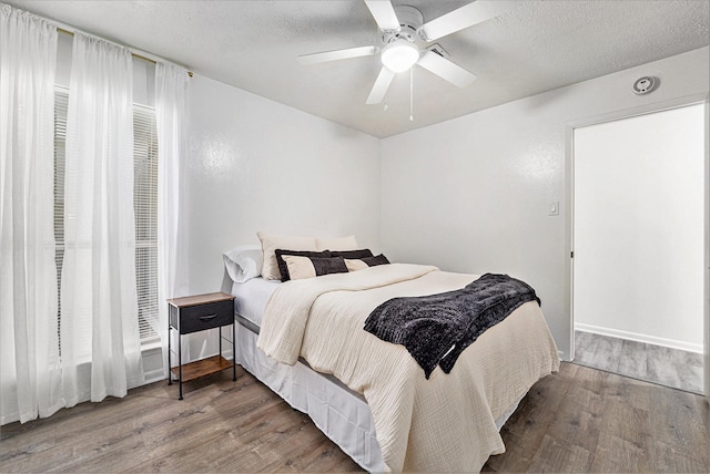 bedroom featuring hardwood / wood-style floors, a textured ceiling, and ceiling fan