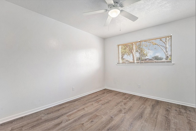 spare room with a textured ceiling, ceiling fan, and light hardwood / wood-style flooring