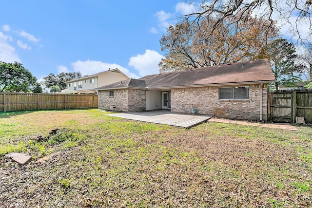 back of house with a wooden deck and a lawn